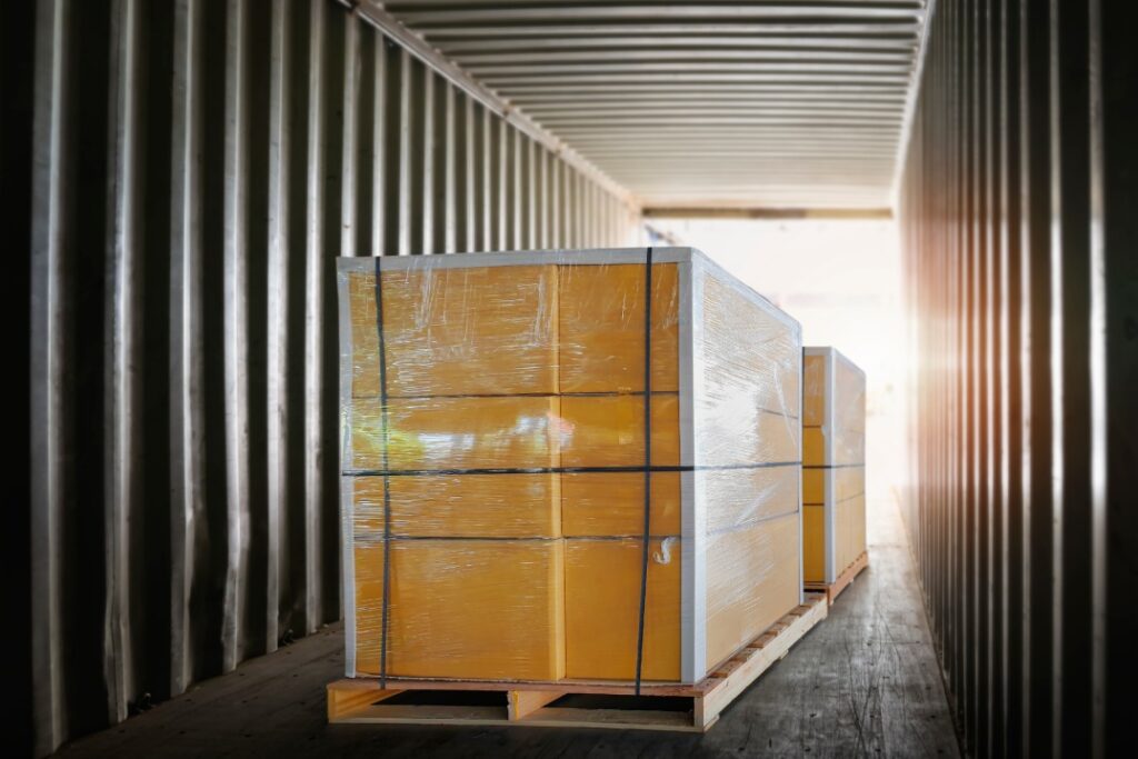 Packaging Boxes Stacked on Pallets Inside Cargo Container. Shipment Boxes Loading Trucks. Shipping Supplies Warehouse Goods. Freight Truck Transport Logistics