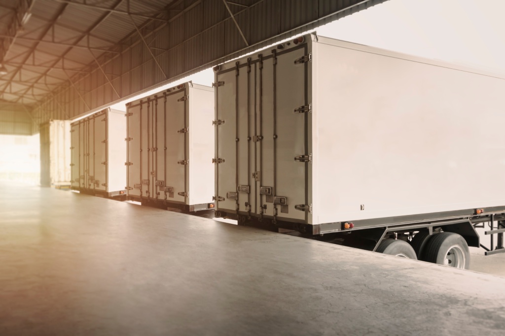 Cargo Container Trucks Parked Loading Dock at Dock Warehouse. Shipping Trucks. Cargo Freight Trucks Transport. Warehouse Logistics.